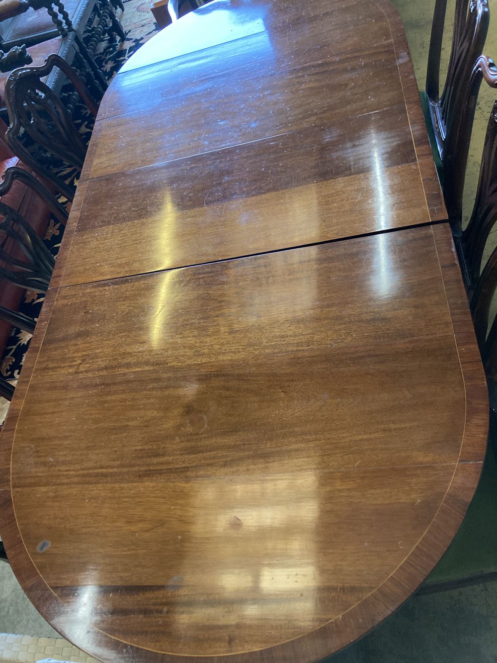 A set of seven George III style mahogany dining chairs (one with arms) together with a mahogany twin pillar extending dining table, 208